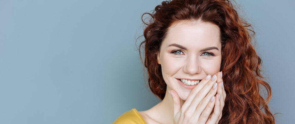 Woman with yellow top relaxed, smiling into camera