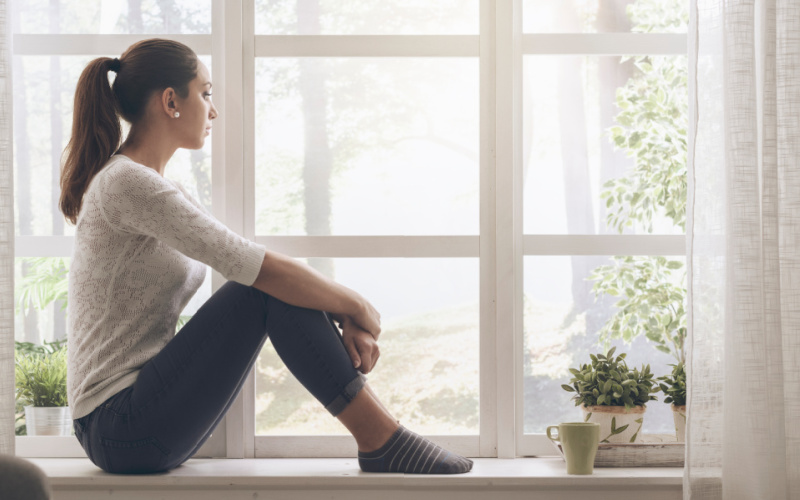 worried mom looking out the window-unemployed and pregnant