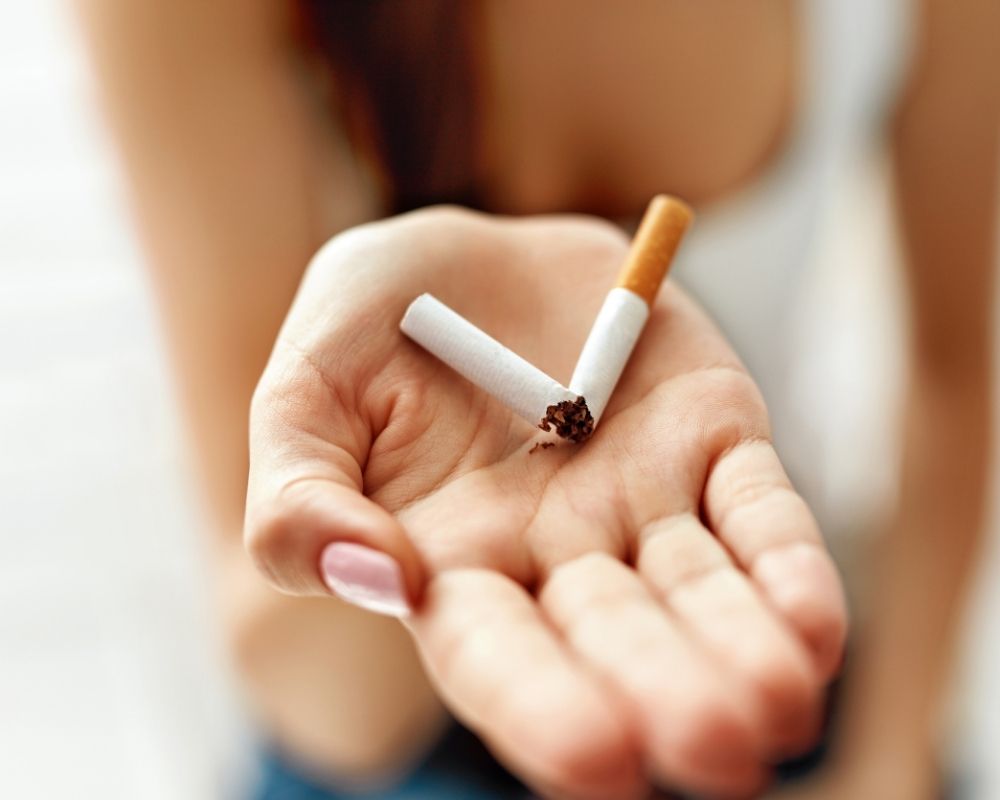 Woman holding a broken cigarette-quit smoking concept