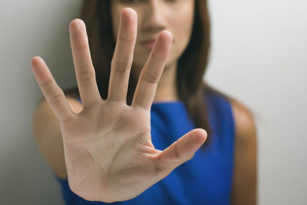 Woman holding up hand to communicate "stop".