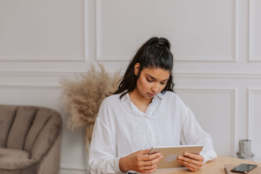 Young woman looking down at a tablet.