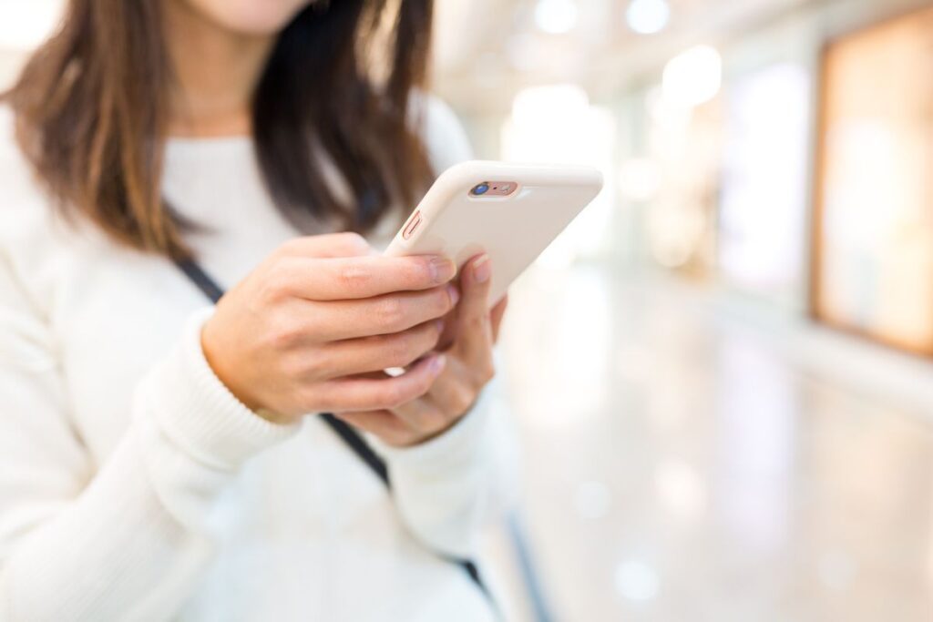 Woman holding her phone, sending a text.