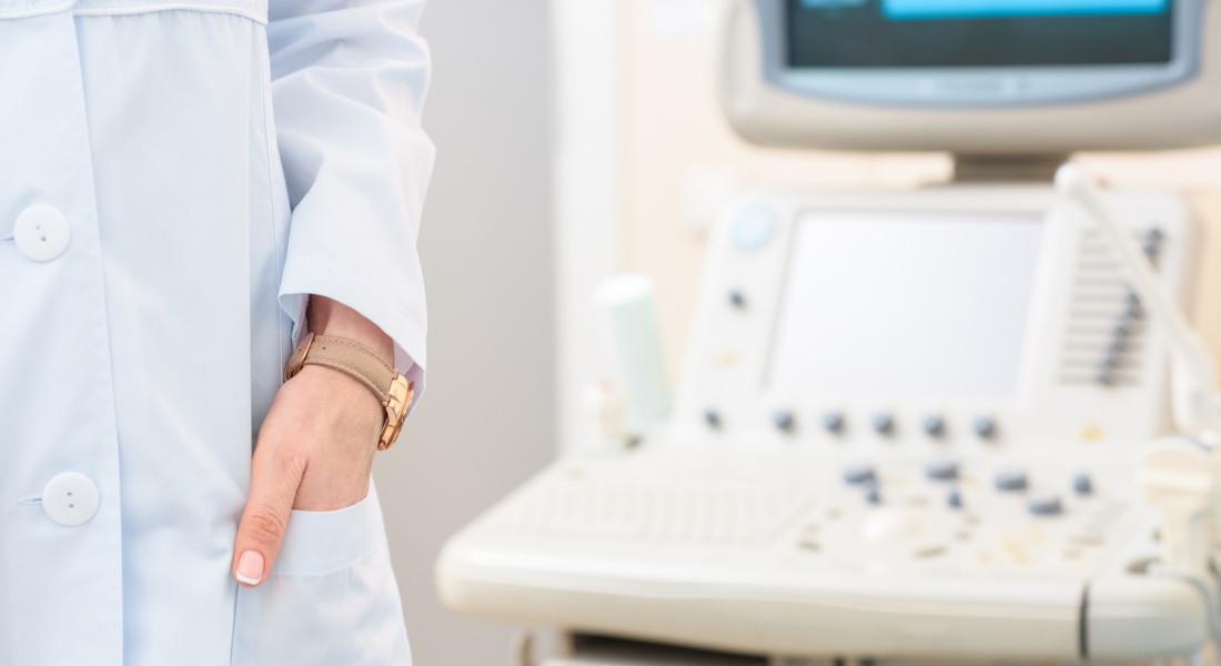 health practitioner standing next to ultrasound machine.