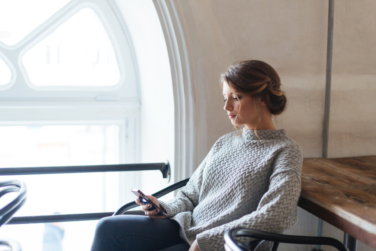 Young woman on mobile phone in a thoughtful pose.