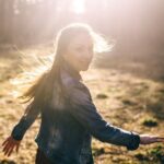 Woman standing outdoors in sunlight