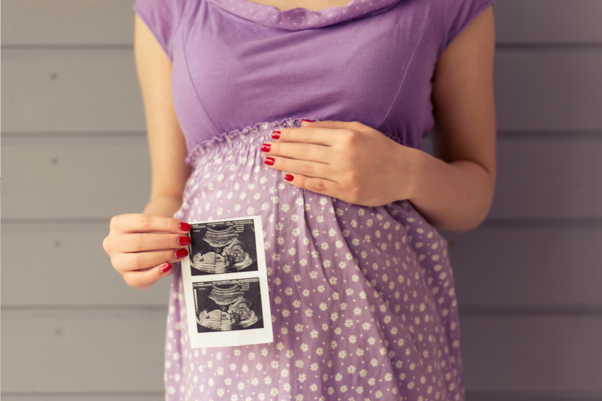 Pregnant woman holding sonogram picture
