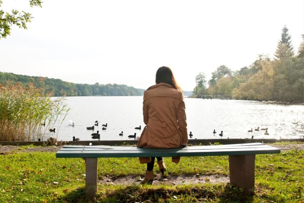 Woman sitting on a park bench alone.