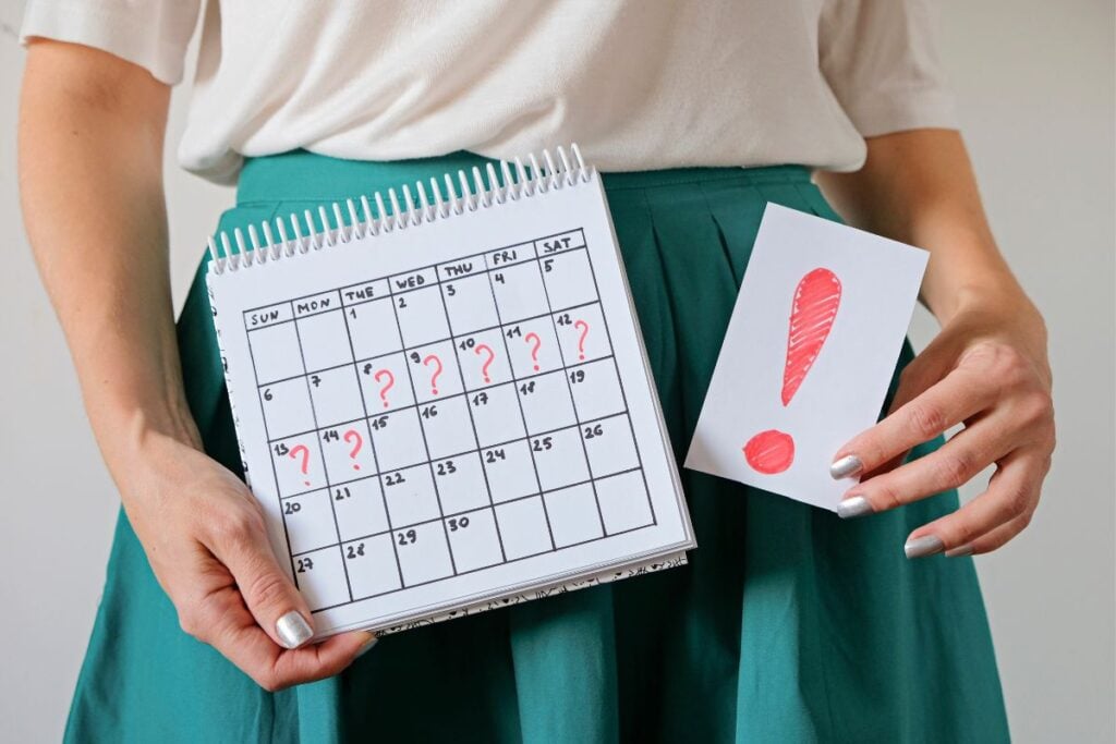 Woman holding calendar with question marks and a sign with an exclamation point