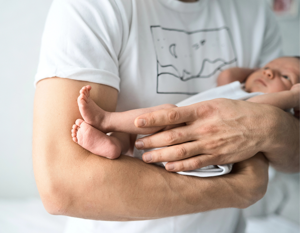 Man holding newborn in his arms.